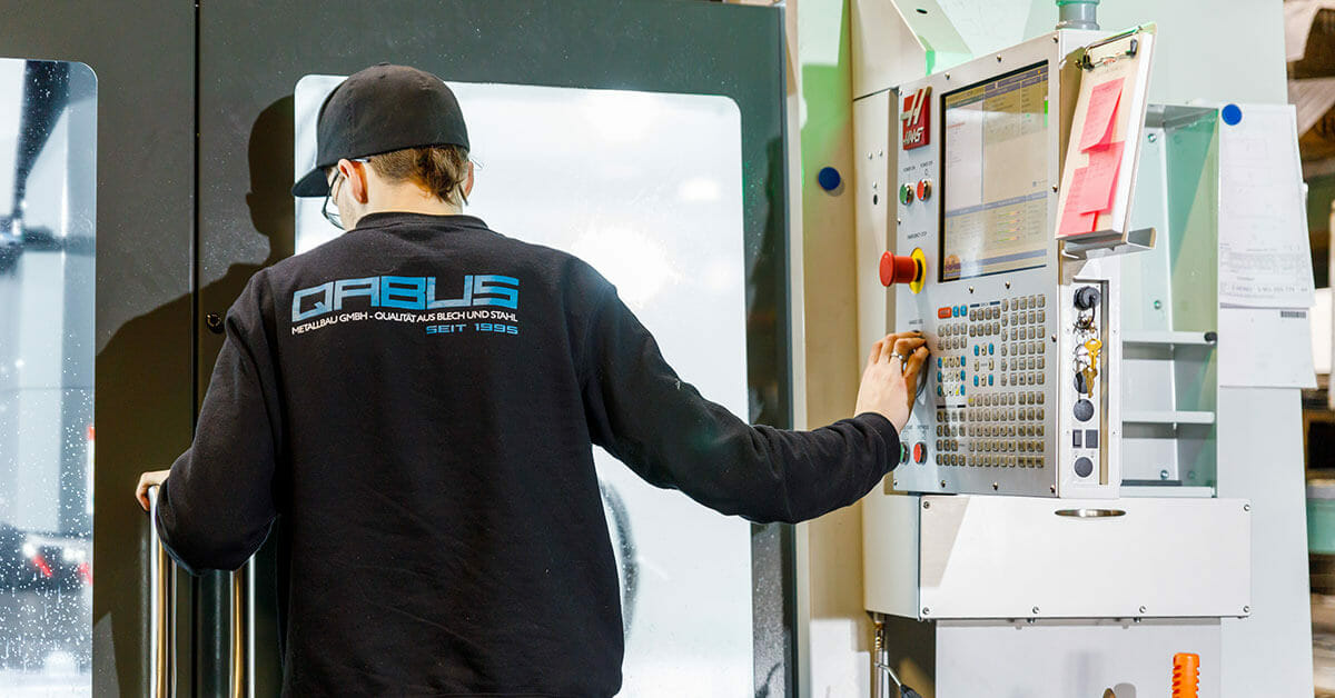 Mitarbeiter an der CNC Fräse bei QABUS
