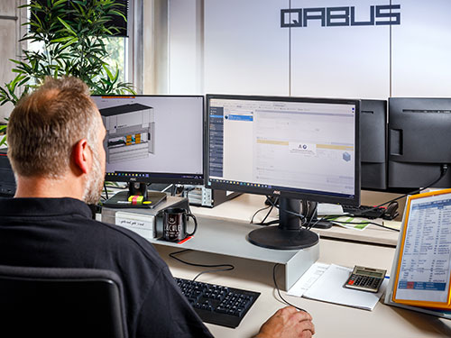 Mitarbeiter prüft CAD Pläne bei QABUS