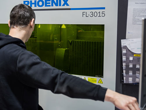 Mitarbeitender von QABUS an der Laserschneidanlage