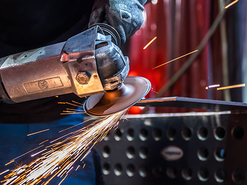 Mitarbeiter bearbeitet Werkstücke bei QABUS nach