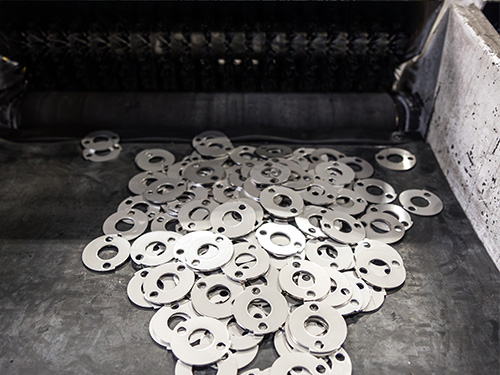 Werkstücke kommen aus der kombinierten Stanz-Laser-Anlage