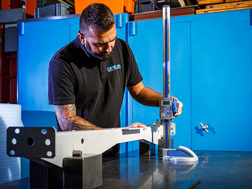 Mitarbeiter prüft die Qualität von CNC Frästeilen